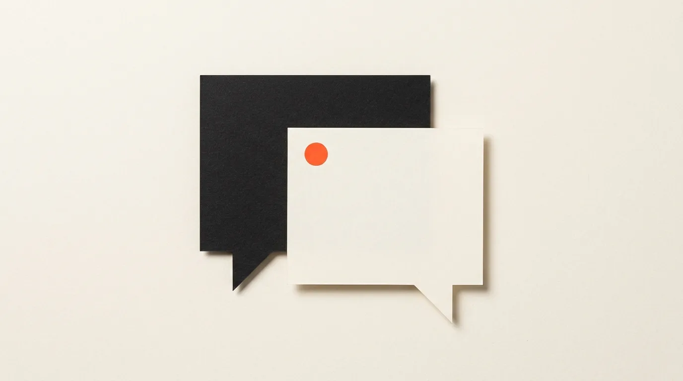 Cut-paper illustration: two overlapping speech bubble shapes cut from paper, one black and one off-white, in black and off-white with one red-orange accent